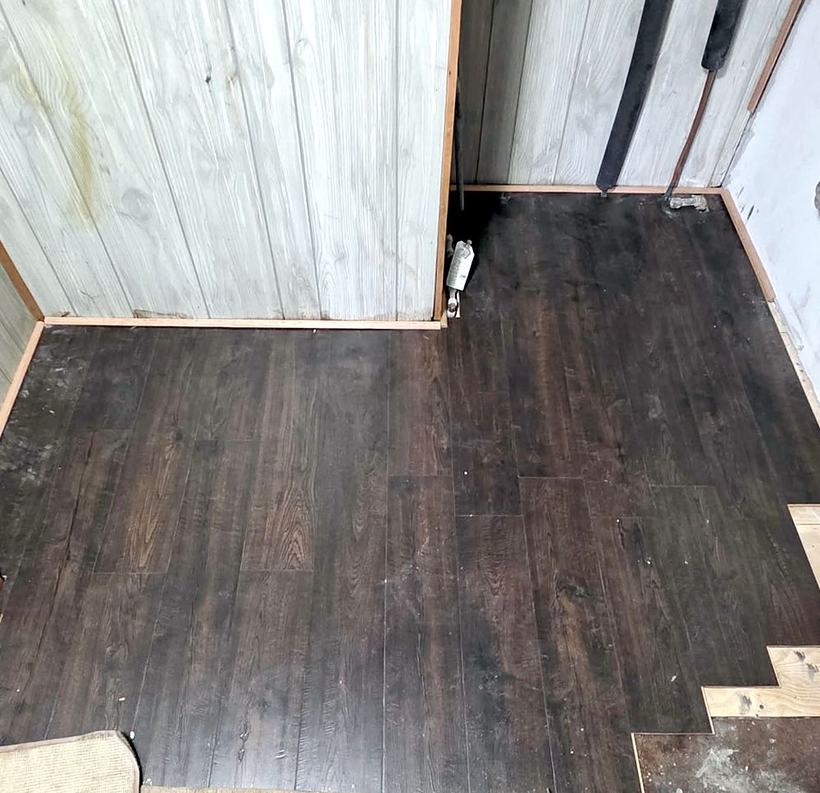Finished: dark wood-look plank flooring in the laundry room