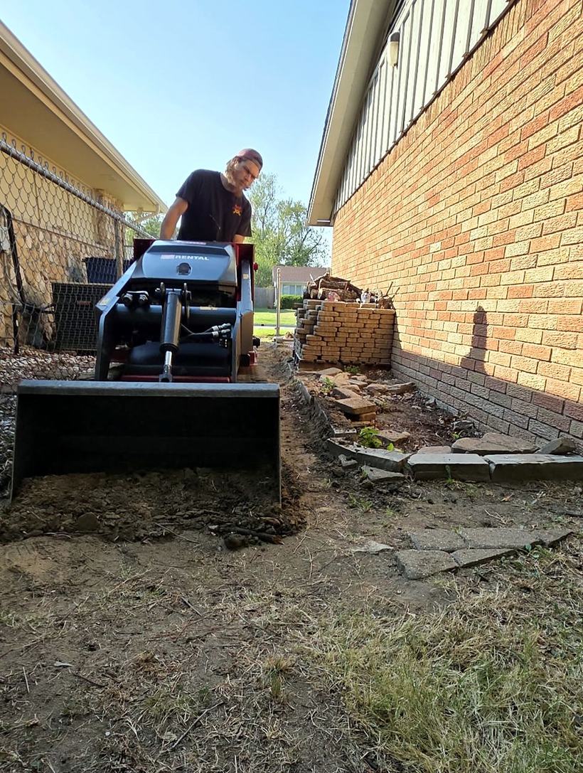 Digging out the side yard for a walkway with a mini skid steer